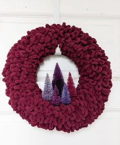 a red wreath with purple trees on it