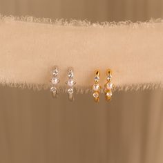 Add a hint of classic charm to your jewelry collection with our Pearl Diamond Huggies ♡ These earrings are your go-to choice when you want to keep it stylish yet relaxed, whether you're running errands or attending a charming wedding! Material: High-Quality Solid 925 Sterling Silver Finish: Sterling Silver ∙ 18K Gold ∙ Rose Gold Hoop Dimensions: ~8 Inner Diameter | ~11mm Outer Diameter Featuring Dainty Huggie Hoop Earrings with ~1.5mm CZ Diamonds and ~2mm Pearls Sold as a Pair Part of our Pearl Elegant Tarnish Resistant Huggie Earrings For Wedding, Elegant Wedding Huggie Earrings Tarnish Resistant, Elegant Tarnish-resistant Huggie Earrings For Weddings, Elegant Hypoallergenic Cartilage Earrings For Anniversary, Hypoallergenic Elegant Cartilage Earrings For Anniversary, Gold Cartilage Earrings For Wedding, Elegant Cartilage Earrings For Anniversary, Dainty Everyday Crystal Earrings, Dainty Crystal Earrings For Everyday