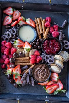 a platter filled with fruit, chocolate and pretzels