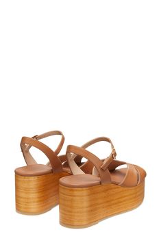 A chunky woodgrain platform and lofty wedge heel add statement-making height to a stylish sandal fitted with an adjustable strap at the ankle. 3" heel; 1 1/2" platform (size 8.5) Adjustable ankle strap with buckle closure Textile or leather upper/synthetic lining/leather and synthetic sole Made in Spain Summer Wedge Sandals With Wooden Block Heel, Modern Brown Platform Wedge Sandals, Summer Platform Clogs With Ankle Strap, Summer Ankle Strap Platform Clogs, Summer Wooden Stacked Heel Heels, Beach Wedge Sandals With Wooden Heel And Ankle Strap, Wooden High Heel Sandals For Summer, Summer Open Heel Wooden Heels, Summer Open Toe Wood Heels