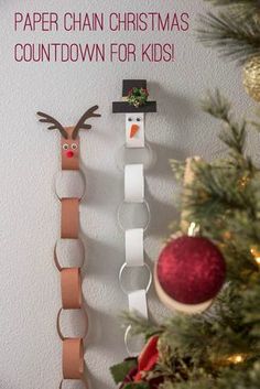 paper chains are hanging on the wall next to a christmas ornament and snowman