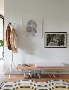 there is a bench in the room with shoes on it next to a coat rack