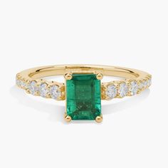 an emerald and diamond ring in yellow gold