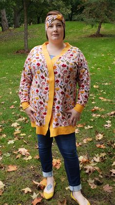 a woman standing in the grass with her hands on her hips and wearing yellow shoes