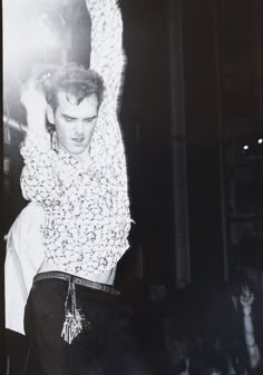 black and white photograph of a man with his arms in the air while standing up