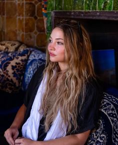 a woman with long hair sitting on a couch