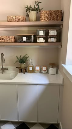 a kitchen with shelves above the sink and various items on the counter top in front of it