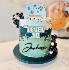 a cake that has a video game controller on it and beads around the edges, sitting on top of a table