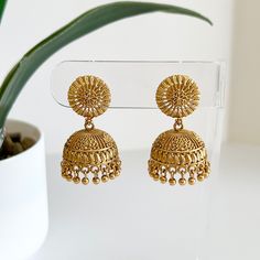 Nothing makes a statement better than a pair of small beautifully designed traditional gold jhumkas! Pair these beauties with your favorite attire. Length: 1.5" | Width 1" Items are carefully packed and ready for gifting. All pictures are taken in natural light please allow for slight variations in color due to camera settings. Jewelry Care ✨Protect your jewelry in a closed box or pouch   ✨Wear jewelry after you have applied lotion or perfume ✨Gently buff with a soft cotton cloth  Visit our webs Small Gold Jhumka, Cheap Gold Wedding Jhumkas, Cheap Gold Jhumkas, Gold Jhumkas For Navratri, Gold Tilla Jhumkas Drop Earrings, Gold Jhumka, Gold Drop Earrings For Navratri, Elegant Gold Jhumkas For Rituals, Gold Brass Drop Jhumkas