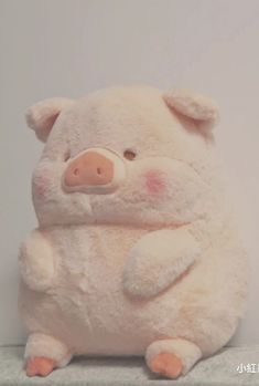 a white stuffed pig sitting on top of a counter next to a wall with the caption, i am not sure what this is