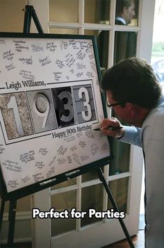 a man is writing on a sign in front of him