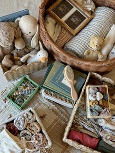 a basket filled with lots of stuffed animals and other items on top of a bed