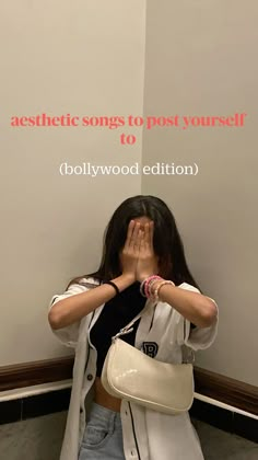 a woman covering her face while standing in front of a wall with the words aesthetic songs to post yourself to