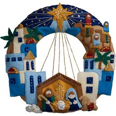 a blue and white christmas ornament hanging from the ceiling with an image of a nativity scene on it