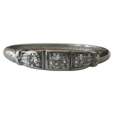 an antique diamond ring with three stones in the middle and four diamonds on each side