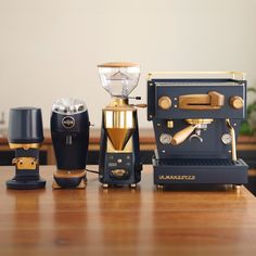 three different types of espresso machines sitting on a wooden table next to each other