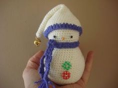 a crocheted snowman ornament with a bell on it