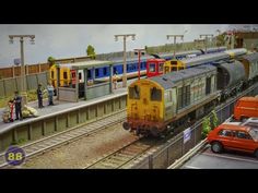 there are many trains on the tracks at this train station, and one is waiting for passengers to board