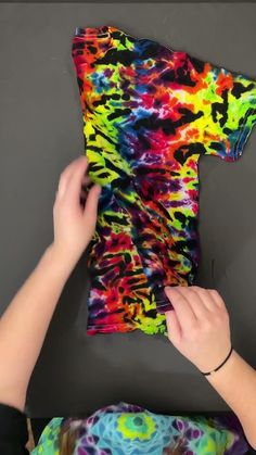 someone is making a colorful t - shirt out of fabric