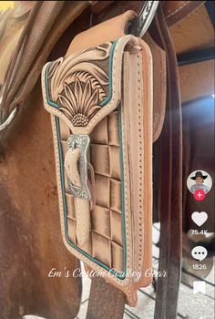 a brown horse saddle with a turquoise and white design on the inside of it's side