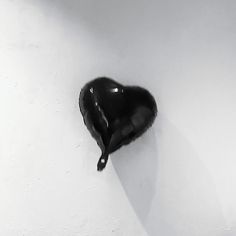 a black heart shaped object hanging on the wall