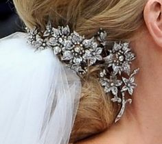 the back of a bride's head wearing a bridal hair comb with flowers on it