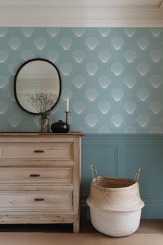 a dresser with a mirror on it next to a wallpapered wall in a room