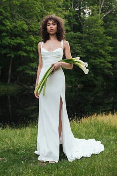 a woman in a white dress holding flowers