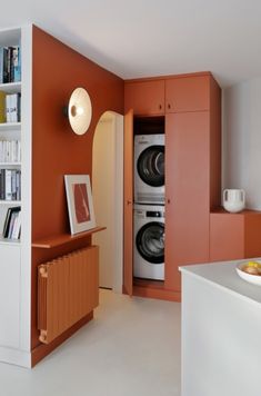 a washer and dryer in a room with orange walls