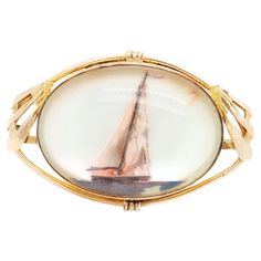 A fine signed Art Deco American nautical costume jewelry brooch. By AMCO Jewelry of Providence, RI. With a gold-plated Art Deco setting and a mother-of-pearl medallion decorated with a sailboat at sea under bezel (mimicking an Essex crystal). Marked to the interior rim 1/20 10k / AMCO. Set with its original pin & catch. Simply a wonderful American nautical or maritime brooch! Date: Early 20th Century Overall Condition: It is in overall good, as-pictured, used estate condition. There is some ligh Nautical Style Metal Jewelry Gift, Gold Nautical Jewelry For The Beach, Gold Nautical Jewelry With Star Charm, Gold Nautical Anchor Jewelry, Nautical Anchor-shaped Gold Jewelry, Antique Signs, Mermaid Jewelry, Nautical Jewelry, Plate Art