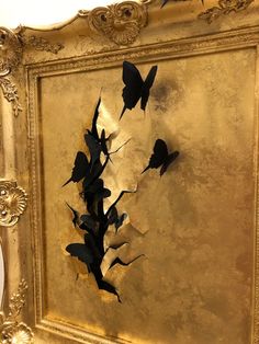 a gold frame with some black butterflies on it