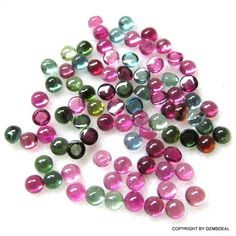 some very pretty colored beads on a white surface