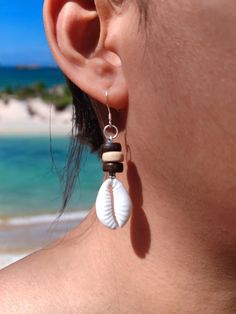 Cowrie Shell Earrings Natural Beach Earrings Perfect Boho Style Earrings in Sterling Silver Hook Embrace the essence of the beach and the free-spirited charm of boho style with our Cowrie Shell Earrings. Each earring features a beautifully polished natural cowrie shell, capturing the ocean's timeless allure. These earrings are designed to complement any outfit, whether you're strolling along the shoreline or dancing the night away at a summer festival. Key Features: Natural Cowrie Shells: Sourced from pristine beaches, each shell retains its unique shape and texture, making every pair one-of-a-kind. Boho Style: The bohemian-inspired design adds a touch of effortless elegance and earthy vibes to your look. Sterling Silver Hooks: Crafted with high-quality sterling silver, the hooks are hypoa Bohemian Shell Jewelry For Beach, Bohemian Dangle Earrings For Beach, Bohemian Shell Jewelry For Beach Season, Bohemian Beach Jewelry For Beach Season, Bohemian Beach Jewelry For Vacation, Bohemian Jewelry For Beach Vacation, Single Drop Earring For Vacation, Summer Shell Dangle Jewelry, Shell-shaped Jewelry With Matching Earrings For The Beach