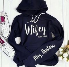 Listing is for a wifey hoodie with the sleeve print. Under the personalization box, please leave me the name for the sleeve and the Est. Unisex hoodie sweatshirt. We suggest sizing down for a women's fit or sticking with your normal size for a loose fit. To order the hubby sweatshirt, please order it as a custom order. Link below. https://www.etsy.com/listing/1107549872 and order it as a custom sweatshirt. Requesting a preview of your order will only delay the processing time. Your sweatshirt wi Hubby Sweatshirt, Bride Hoodie, Wifey Sweatshirt, Honey Moon, Womens Hoodies, Couples Hoodies, Custom Sweatshirts, Couple Outfits, Crew Sweatshirts