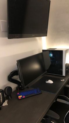 there is a monitor and keyboard on the desk