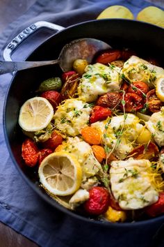 a pan filled with lemons, strawberries and other food on top of a table