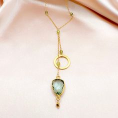 Our ballet collection is designed to be both modern and feminine. Pairing a beautiful circle accent with a green amethyst gemstone (also known as prasiolite) in the graceful, signature design of our ballet necklace. 14k gold plated over fine Italian silver. Necklace chain is adjustable up to 2”.Total chain length with drop is 19".Handmade. Gold Jewelry With Green Amethyst Birthstone, Elegant Adjustable Necklace With Gemstone Accents, Chic Gold Necklace With Gemstone, Chic Gold Necklaces With Gemstone, Elegant Green Amethyst Jewelry For Gifts, Elegant Faceted Green Amethyst Jewelry, Gold Necklace With Green Amethyst Gemstone, Modern Gold Necklaces With Gemstone Accents, Delicate Gold Necklaces With Gemstone Accents