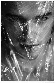 a black and white photo of a man wrapped in plastic