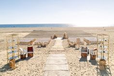 an empty sandy beach with chairs and tables set up for a wedding on the sand