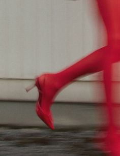 a woman's legs and red shoes are seen in this blurry photo,