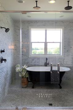 a bath tub sitting next to a window in a bathroom