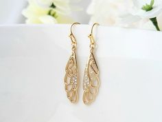 These lovely butterfly wings, will add a touch of beauty to your day! They have a high quality, 24k champagne gold plating. Tiny zircon gemstones also embellish the wings. They can be dressed up or down, and will compliment a variety of attire. Product details: * 18k gold plated ear wires; Lead and nickel free * 24k champagne gold plated wings * Clear zircon gemstones - Length:   1.5 inches - Width:    .3 inches ❤ Click the link, to see more unique jewelry from Flutterbird: https://www.etsy.com/shop/FlutterbirdCo My goal is to provide every customer with exceptional service. Please message me if you have any questions. Thank you for supporting my small business!  Please visit my F.A.Q. and shop policy sections for additional info. Jewelry For Champagne Dress, Delicate Gold Crystal Earrings For Party, Gold Delicate Crystal Earrings For Party, Elegant Butterfly Filigree Jewelry, Elegant Butterfly Shaped Filigree Jewelry, Delicate Gold Crystal Party Earrings, Elegant Gold Butterfly Earrings, Elegant Gold Butterfly-shaped Earrings, Gold Butterfly Earrings For Wedding