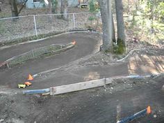 a dirt bike track in the middle of a wooded area with trees and fence around it