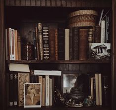 an old book shelf filled with books and other antique books on top of wooden shelves