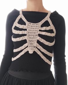 the back of a woman's sweater with a crocheted skeleton on it