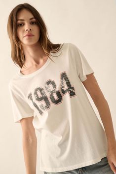 1984 Vintage-Print Varsity Graphic Tee - ShopPromesa Summer Graphic Tee With Number Print, Graphic Tee With Number Print For Streetwear, Text Print, Vintage Canvas, Vintage Prints, Round Neckline, Graphic Tee, Vintage Style, Graphic T Shirt