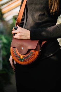 "Unique half round bag with flower. This bag is a reminder that everyone can blossoms! This bag is made of alder tree and leather, manually curving and painted, covered with waterproof lacquer. Bag is closing with magnetic button. Dimensions:  20 x 13 x 6 cm 8 x 5 x 2,3 \" The wood colour is just exactly like on the photo, the secondary colour is a colour of leather.  There is enough space for a huge list of woman necessary things( phone, credit card, keys, cosmetic etc).  You can wear it daily or for different events including birthday party, wedding, holidays etc.  Unique accessory which will help you to stay bright even in cloudy days." Bohemian Satchel Saddle Bag For Daily Use, Bohemian Hand Tooled Saddle Bag, Bohemian Tote Saddle Bag For Everyday Use, Traditional Satchel For Everyday Use, Bohemian Saddle Tote Bag For Everyday Use, Bohemian Handmade Saddle Bag For Everyday Use, Bohemian Handmade Saddle Bag For Travel, Handmade Bohemian Saddle Shoulder Bag, Traditional Hand Tooled Bag For Festivals