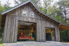 a large wooden building with an open garage door