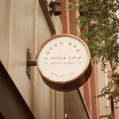 a sign hanging from the side of a building that says dough bros pizza co on it