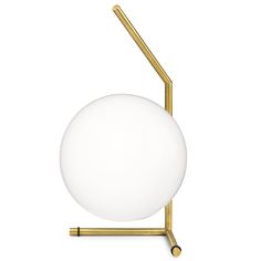 a white ball sitting on top of a metal stand with a gold frame and two brass poles